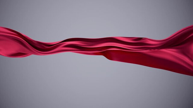 Silky red fabric of vibrant color moving gracefully.