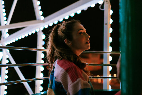 Profile portrait on a ferris wheel at an amusement park at night