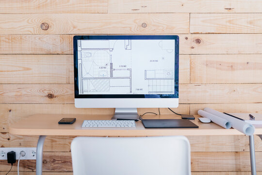 Desk in a home office with floor plan on the computer