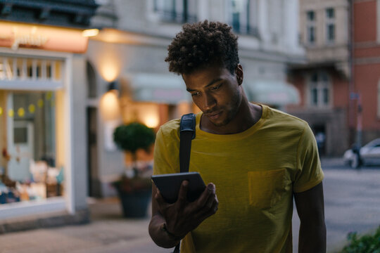 Man looking at phablet in the city at dusk