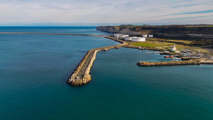 Fototapeta premium Aerial drone view of a supertanker pier and oil tanks on the English Channel coast of Normandy, France. 