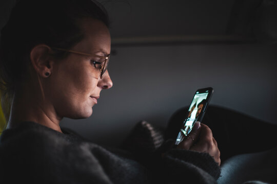 Woman looking at her smartphone during video chat, in a van