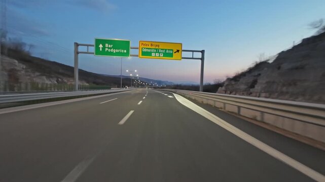 POV driving on modern highway with bright lights illuminating the road at night. Transportation, travel and infrastructure concept, 4k