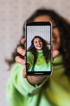 Young woman showing photograph on smart phone