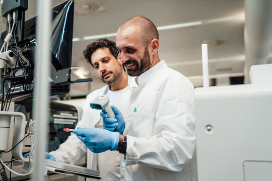 Scientist and technician scanning blood sample barcode in laboratory