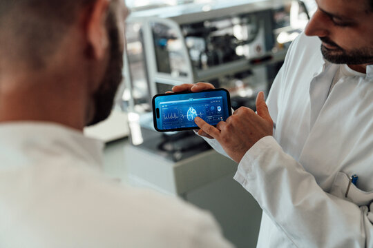 Doctor showing medical brain data on smartphone in the laboratory