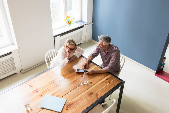 Mature couple using tablet at home
