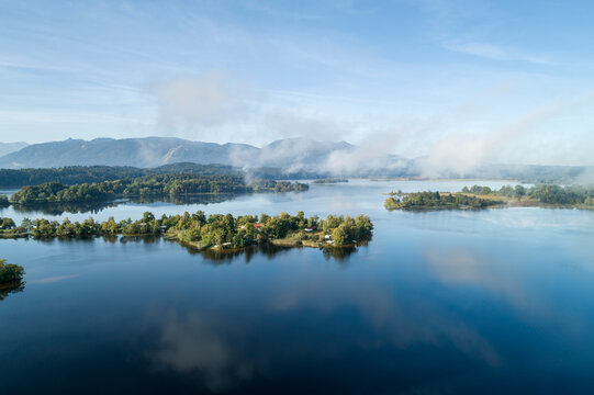 Germany, Bavaria, Murnau am Staffelsee, Drone view of fog floating over Gradeneiland, Worth and Buchau islands on Staffelsee lake
