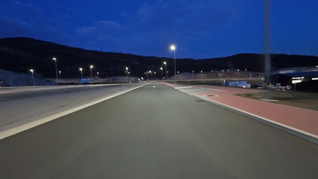 POV driving on modern highway with bright lights illuminating the road at night. Transportation, travel and infrastructure concept, 4k