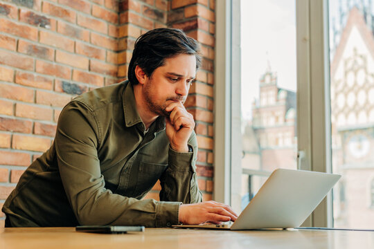 Businessman working on laptop in modern office cafe