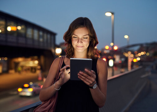 Germany, Hamburg, Young woman in the street using digital tablet