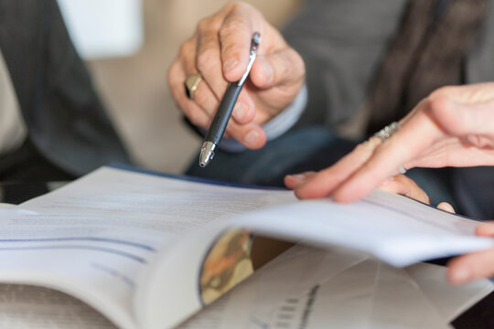 Hands holding booklet and ballpen, close-up