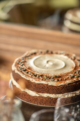 Fototapeta premium A rustic double-layer carrot cake filled and topped with cream cheese frosting, dusted with cinnamon and garnished with pumpkin seeds.