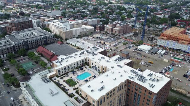 Construction corridor mixes along Meeting St Morrison Dr highlights development beside multifamily structures in Charleston Upper Peninsula. Varied roof tones, exposed framing define area, SC