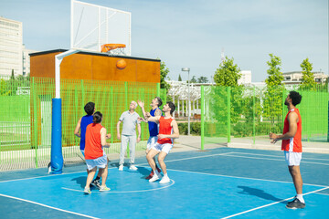 Fototapeta premium Diverse men playing active basketball game outdoors
