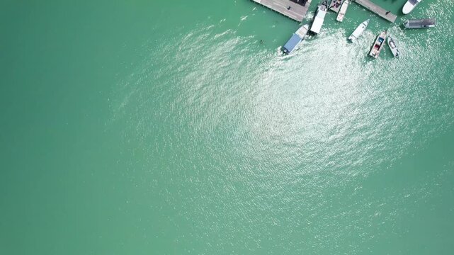 Top down drone shot drifting forward over Clan Jetties in George Town Penang capturing overwater houses and boats near the waterfront