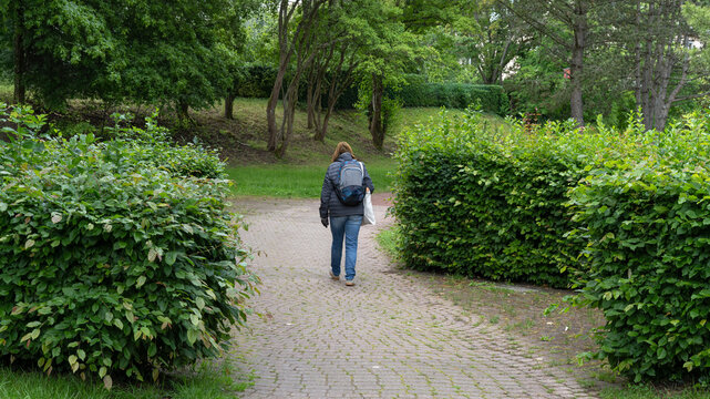 passage d'une personne dans l'all&eacute;e du parc de la ville