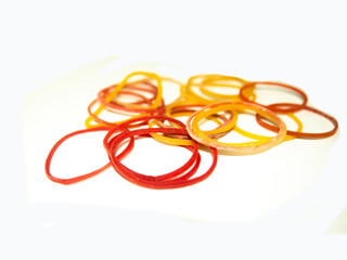 Fototapeta premium Colorful elastic rubber bands pile isolated on white background. Useful for office, school stationery, and packaging concept.