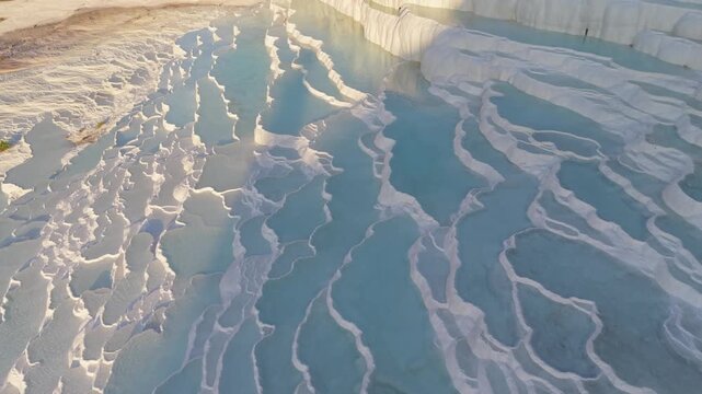Pamukkale Turkey showcases stunning white terraces formed by mineral-rich waters. Visitors can stroll along the pools and admire the vibrant landscape during a golden hour adventure.