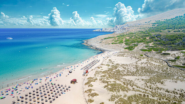 Scenic view of Cala Mesquida beach with turquoise water and sand dunes in Mallorca, Spain