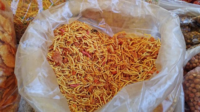 Closeup view of Indian namkeen spicy crunchy mixture displayed in market snack stall