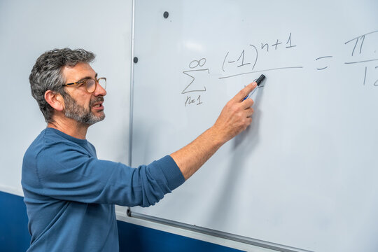 Professor explaining complex math formula on whiteboard