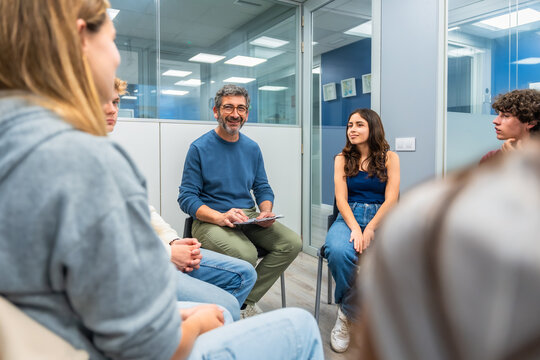 Therapist leading group therapy session with young adults