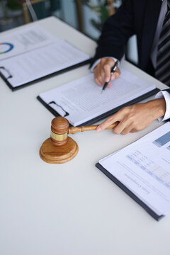 Legal counsel reading contract paperwork to finalize a legal agreement. Concepts for legal counsel, judicial authority, and the finality of a decision or agreement.&nbsp;