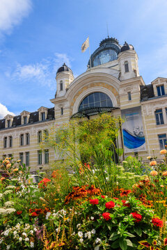 Facade of the historic Palais Lumiere with a beautiful blooming flowerbed in front in Evian, Haute-Savoie, France