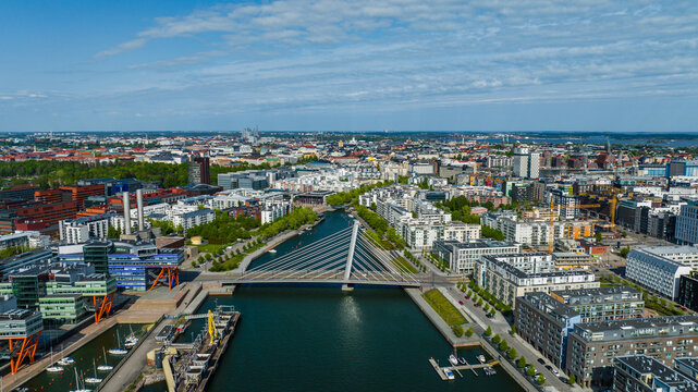 Aerial view of the Ruoholahti district featuring the Crusell Bridge over the canal surrounded by modern architecture and waterfront buildings in Helsinki, Uusimaa, Finland.