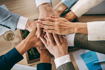 Obraz premium Collaborative teamwork of diverse business professionals joining hands in an office setting symbolizing unity