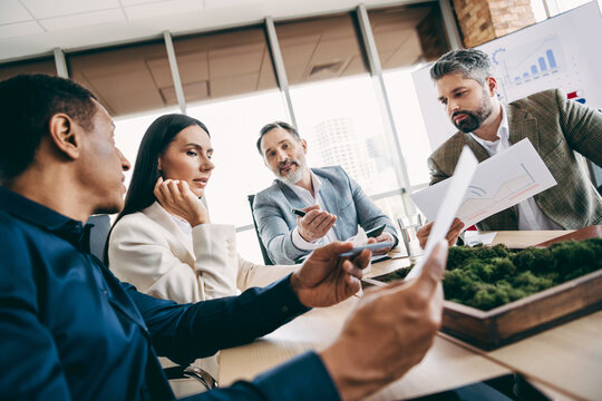 Group of professionals engaging in work discussion in modern corporate office with teamwork and collaboration concepts
