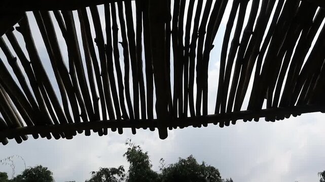 Traditional bamboo roof structure viewed from below in an outdoor setting.
