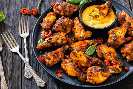 Roasted chicken wings with savory dip, top view
