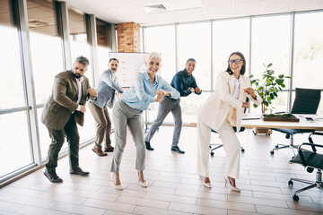 Fototapeta premium Group of professional colleagues enjoying team building activities in a modern office setting showcasing collaboration