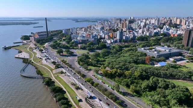 Porto Alegre cityscape and Gua&iacute;ba riverfront park, seen in an aerial pull back shot.