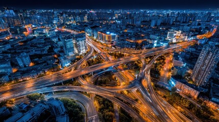 Obraz premium Aerial view of a complex urban highway intersection at night with illuminated structures