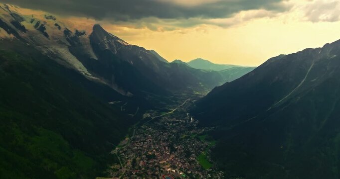 Establishing shot of French mountains in summer. Drone view of green meadows. Establishing shot of mountain range. Aerial slider shot of Chamonix village under Mont Blanc