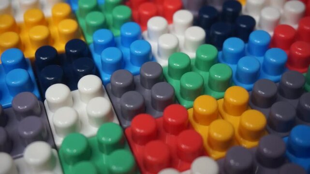 Close-up video of vibrant, colorful plastic interlocking building blocks for children. Perfect background or footage for topics related to early childhood education, creativity, playfulness, STEM lear