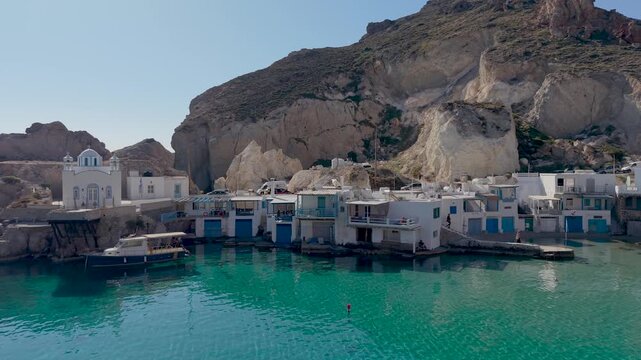 Discover the breathtaking beauty of Firopotamos Milos Island as colorful boats rest by the tranquil, clear waters of Greece