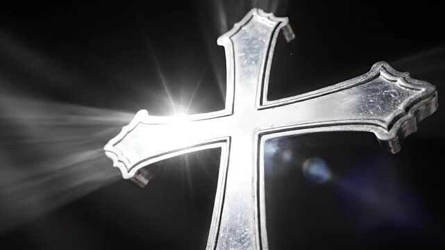 A silver cross gleams under divine light.