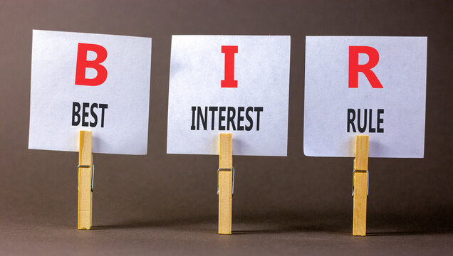 BIR best interest rule symbol. Concept words BIR best interest rule on beautiful white papers on wooden clothespins. Beautiful grey background. Business BIR best interest rule concept. Copy space.
