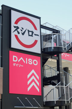 CHIBA, JAPAN - May 13, 2026: Signs for a Daiso shop, a variety store where most products cost 100 yen, and a Sushiro conveyor belt sushi restaurant on a building in Ichikawa City in Chiba Prefecture.