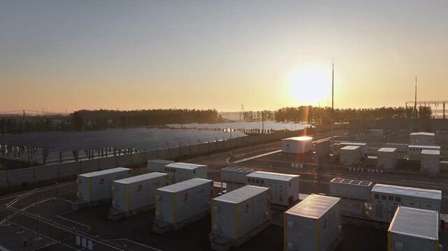 Energy storage container power station at sunset with orderly arranged modules and industrial landscape