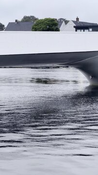 Modern yacht hull at dock with residential houses in Mandal Norway
