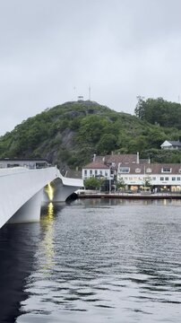 Modern White Bridge Over River with Historic Town and Green Hill in Mandal Norway