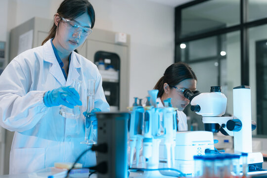 ecologists testing wastewater purity using scientific equipment in sterile cleanroom, environmental sustainability concept.
