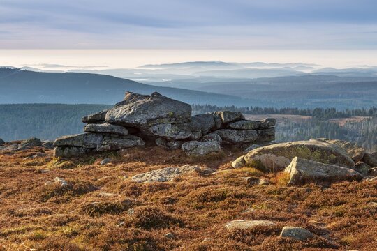 View from the summit of the Brocken to the south over the hills and forests of the Harz with morning fog, in front the Hexenaltar rock formation in the morning light, Harz National Park, Schierke, Saxony-Anhalt, Germany