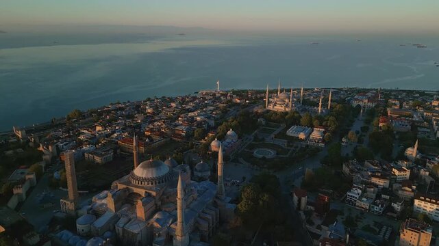 Hagia Sophia and The Blue Mosque in Istanbul with Bosphorus Strait and Sea of Marmara in horizon, aerial view at sunrise in 4k