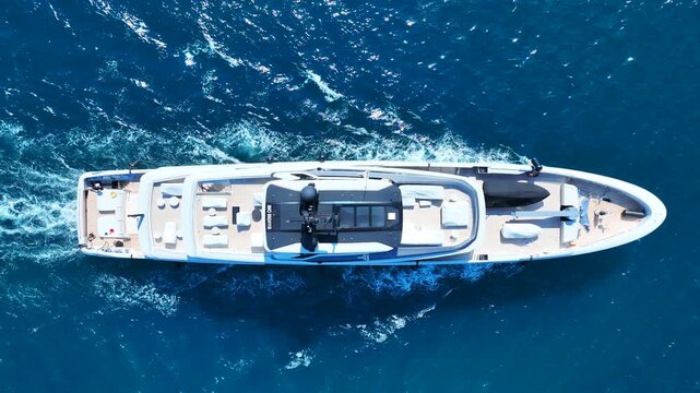Aerial drone cinematic video of luxury yacht with wooden deck cruising in deep blue Mediterranean Sea